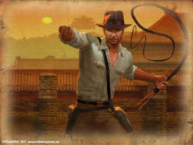A videogame screenshot of Harrison Ford as Indiana Jones. He's a blocky video game character facing the camera with a linen shirt, holding a whip about to strike. It says POWERD BY www.indianajones.de in the bottom left hand corner.